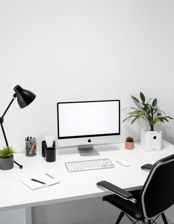 Workplace with computer, stationery and plant on table in officeの写真素材