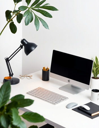 Creative workplace with computer, stationery and plants on white tableの写真素材