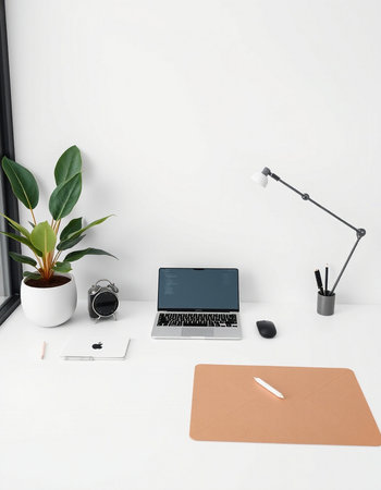 Workplace with laptop, coffee cup, stationery and decorations on white tableの写真素材