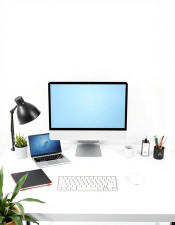 Workplace with computer and stationery on table against white wall background