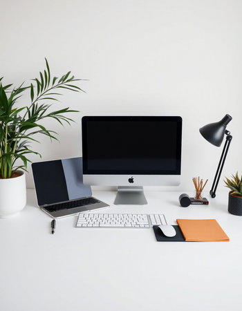 Modern workspace with computer, keyboard, mouse, notepad and plant.