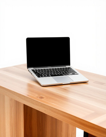 Laptop on a wooden table with white wall in the background.
