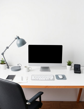 workplace with computer, lamp, keyboard and mobile phone in officeの写真素材