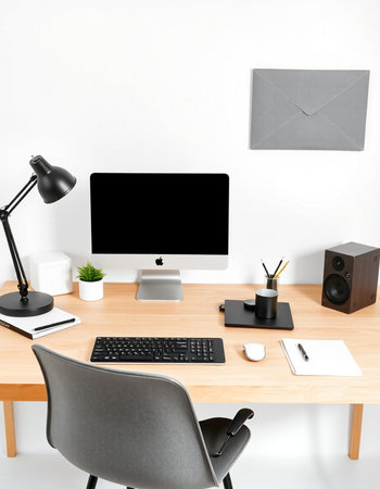 Modern workspace with computer, stationery and copy space on white wallの写真素材