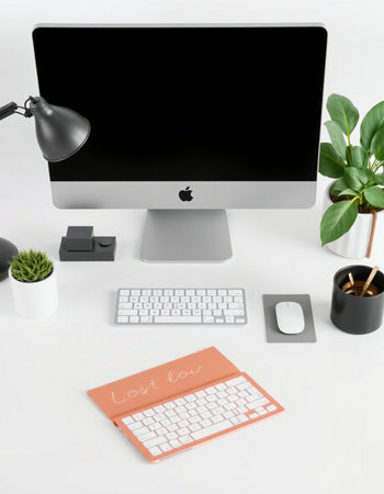 Modern workspace with computer, keyboard, mouse, coffee cup and plant.