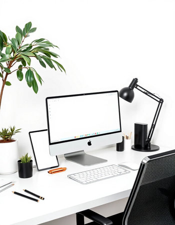 Front view of modern workplace with blank screen computer, mobile phone, stationery and green plant on white table. Mock upの写真素材