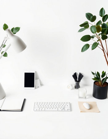 Creative workspace with computer keyboard, smartphone, stationery and plant on white backgroundの写真素材