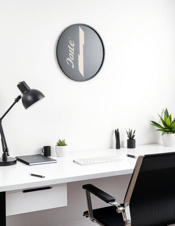 Minimalist workplace with computer, plant, lamp and clock on white wall