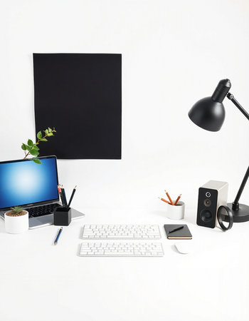 Workplace with computer, keyboard, mouse, lamp, coffee cup and blank black poster on the wall