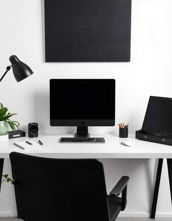 Workplace with computer, lamp and stationery on table in office
