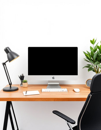 workplace with computer, keyboard, lamp and plant