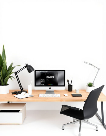 workplace with computer, lamp and plant on table near white wall