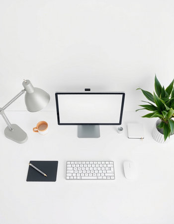 Top view of modern workplace with blank screen computer, coffee cup, stationery and plant on white background. Mock upの写真素材