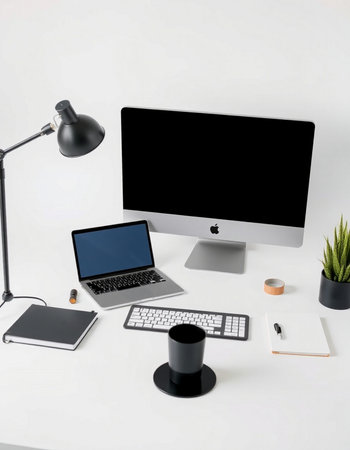Modern workspace with computer, supplies and coffee cup on white table.