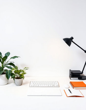 Minimal workspace with computer, keyboard, stationery and plant on white backgroundの写真素材