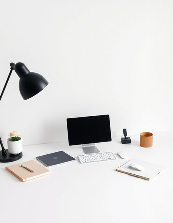 Minimalistic workspace with computer, stationery and coffee cup on white tableの写真素材