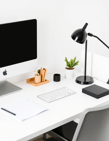 workplace with computer, lamp and stationery on white table in office