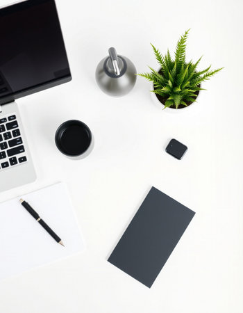 White office desk table with laptop, coffee cup, notebook, pen and plant. Top view with copy space, flat lay.の写真素材
