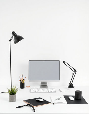 Minimal workspace with blank computer screen, stationery and accessories on white tableの写真素材