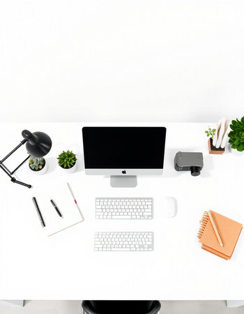 Top view of modern workplace with blank screen computer, stationery and other items on white table....