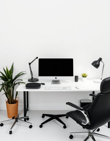 workplace with modern computer, lamp and plant on white wall backgroundの写真素材