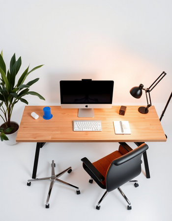 Top view of modern workplace with computer, keyboard, mouse, lamp and plantの写真素材