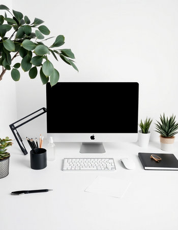 Modern workspace with computer, stationery and green plants on white backgroundの写真素材