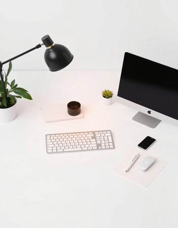 Office desk table with computer, keyboard, mouse, smartphone and plant.