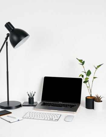 Laptop with blank screen on white office desk with keyboard, stationery and plantの写真素材