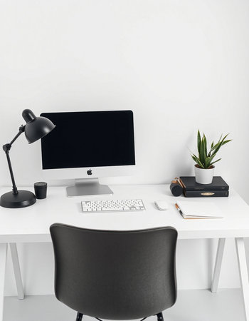 workplace with computer, lamp, notebook and plant on white tableの写真素材
