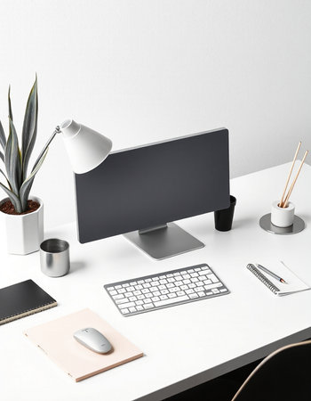 Minimalistic workplace with computer, supplies and stationery on white table. Workplace conceptの写真素材