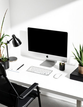 workplace with computer, keyboard, lamp and plant in modern office