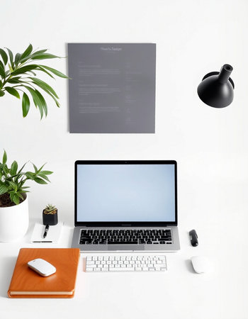 Modern workplace with laptop, stationery and decorations on white wall backgroundの写真素材