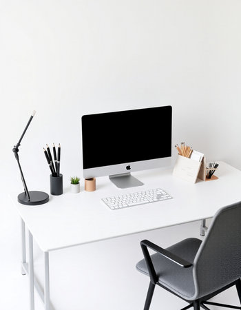 Minimalistic workplace with computer, stationery and copy space on white wallの写真素材