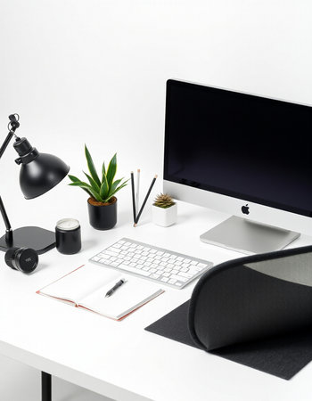 Minimalistic office workplace with computer, supplies, coffee cup and other items on white table