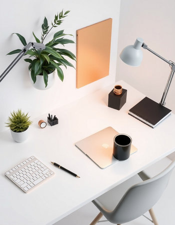 Minimalistic workplace with laptop, coffee cup and other items on white tableの写真素材
