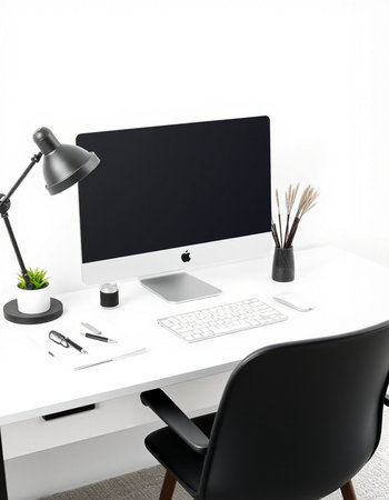 Modern workplace with computer, lamp and stationery.