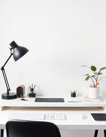 workplace with computer, lamp, stationery and plant on table