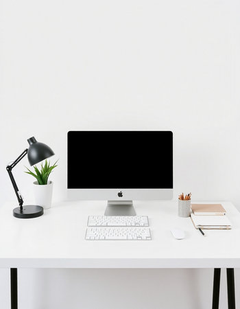 Minimal workspace with computer, stationery and coffee cup on white table