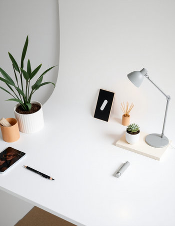 Minimal workspace with tablet, smartphone, stationery and plant on white tableの写真素材