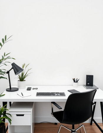 workplace with computer, lamp, notebook and plant on white wallの写真素材
