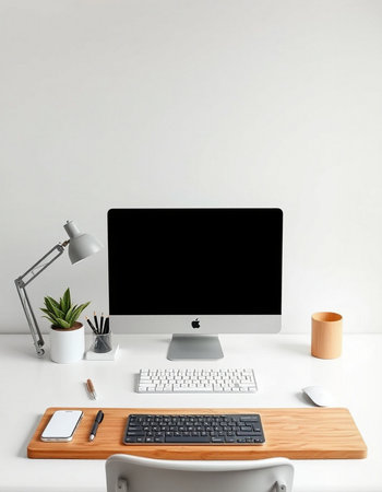 Minimalistic workplace with computer, supplies and coffee cup on white tableの写真素材