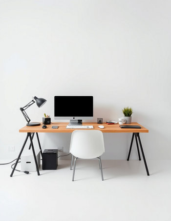 Workplace with computer, lamp and other objects on white wall backgroundの写真素材