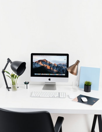 workplace with computer, lamp, plant and keyboard on white deskの写真素材