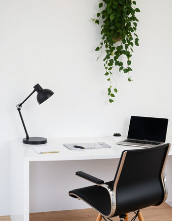 Modern office interior with wooden desk, laptop and plant on the wallの写真素材