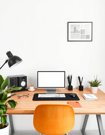 Workplace with blank screen computer, mobile phone, stationery and plant on wooden tableの写真素材