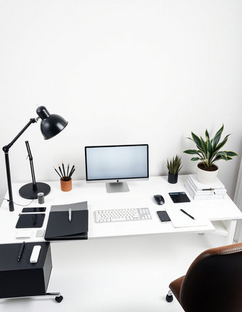 workplace with computer, lamp, stationery and plant in officeの写真素材