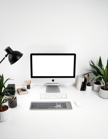 Workplace with computer, stationery and plants on white wall backgroundの写真素材