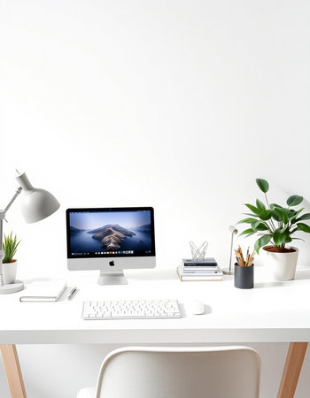workplace with computer, lamp, books and plant on the table