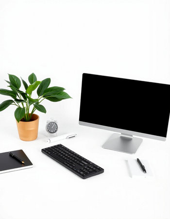 Modern workspace with computer, keyboard, mouse, notebook and plant.